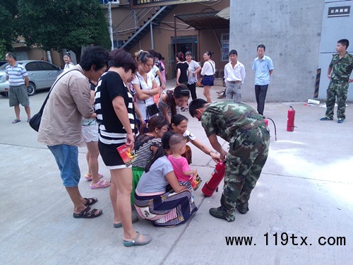 圖為現(xiàn)場群眾操作滅火器。(鄭佳嵐)