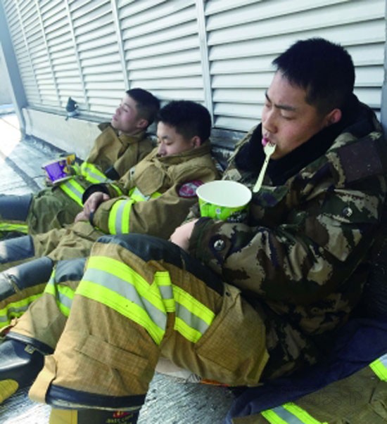 奮戰一夜后,消防戰士郭武警手捧泡面睡著了